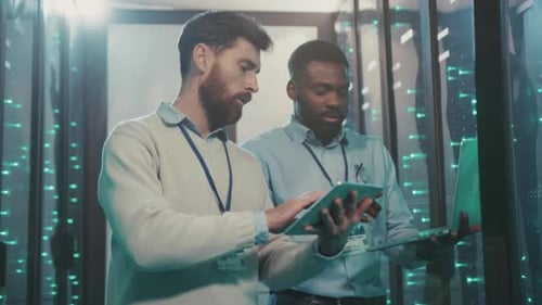 Data center workers inspecting server equipment using technology