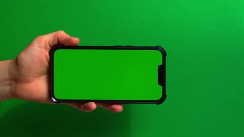 Hands Holding Cell Phone with Green Screen on Green Background