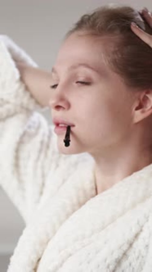 Woman Styling Hair in Robe