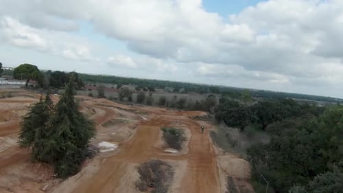 Motocross riders hit dirt banked turns in sync aerial overview