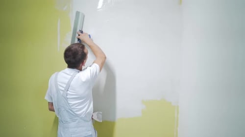Man Plastering Wall with White Material