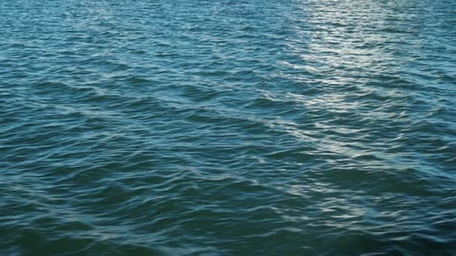Tranquil ocean waves gently ripple against the sky. Suitable for relaxation and travel projects.