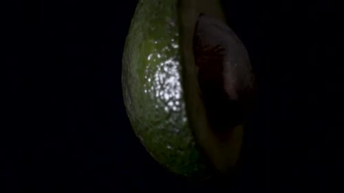 Close up shot of avocado spinning with a black background