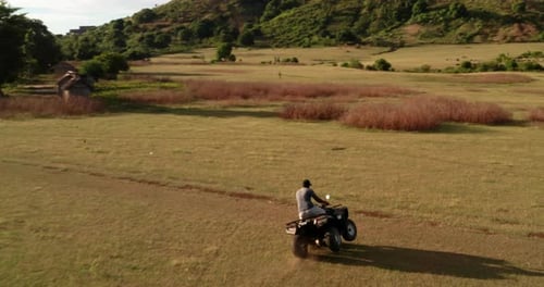 Slow motion of tourist is driving with quad bike or ATV in Madagascar between a wildlife nature.