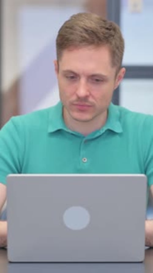 Man Working on Laptop in an Office Setting