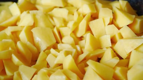 Close-up of cutting potatoes for frying in a pan