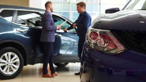 Men Shake Hands at Car Dealership