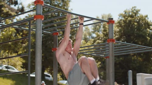 Shirtless Man Does Abdominal Exercises on Bars