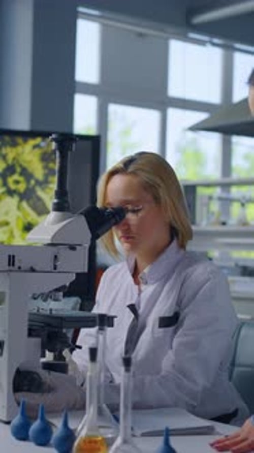 Scientists Working With Microscope in Lab Environment