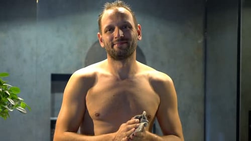 Man drying himself after a shower in bathroom