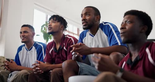 Excited Friends Watch Sports Game Together on Sofa