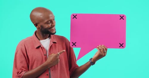 Man Presents Pink Speech Bubble on Light Blue Backdrop