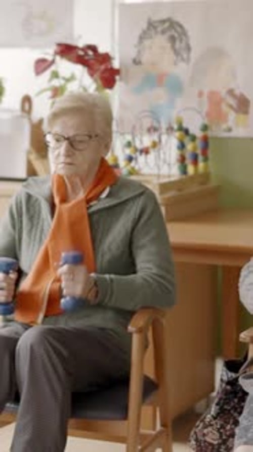 Seniors Exercising in a Nursing Home Using Pedals and Dumbbells