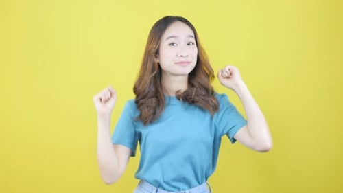 Enthusiastische Asiatin sagt Ja, sieht glücklich aus und feiert den Sieg, Fist Pump Dance Champion