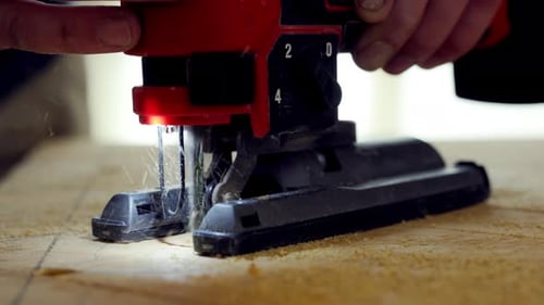 Person Using the Jigsaw Power Tool Worker is Holding Jigsaw with Both Hands Guiding It Along Marked