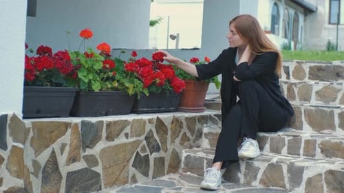 Alone Beautiful Young Woman Enjoying Beautiful Flowers in Her Garden Near Her House