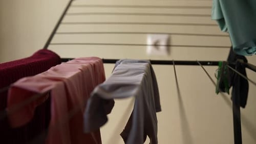 Taking Clean Clothes Off Drying Rack Indoors