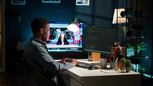 Афроамериканский эксперт за столом, использующий ПК для программирования и анализа данных