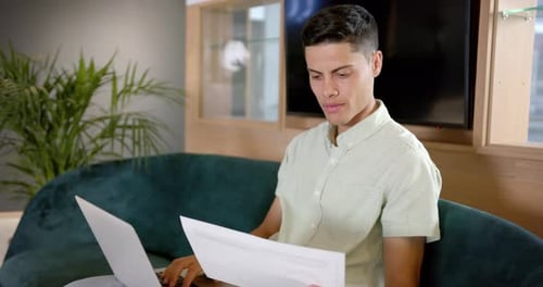 Young Adult Works on Laptop at Home