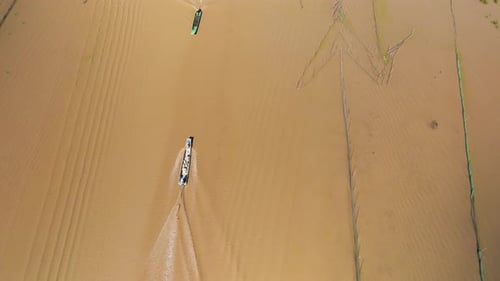 Aerial drone view of fishing boat traffic on the Tonle Sap. Fishing boat passing arrow head designed