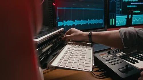 Anonymous Musician Adjusting Audio Controls in Recording Studio