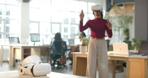 African American woman with VR headset clenching fists, navigating virtual interface at office desk