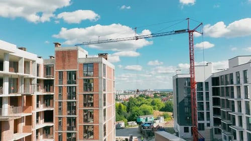 Construction of a Multistorey Building Aerial Flying Over an Unfinished Red Brick House