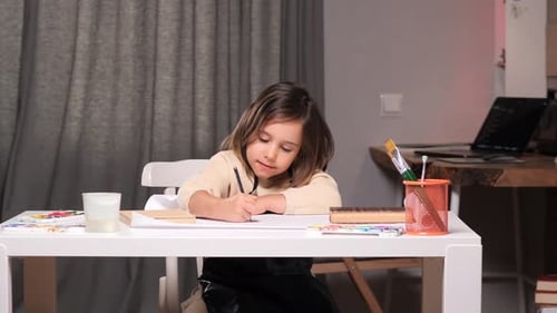 Little Girl Drawing Picture with Pencil Indoors