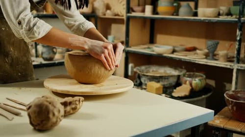 Creating handicraft pottery closeup of working table in ceramics studio with female master