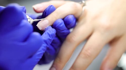 Manicurist Filing Nails with Electric Nail File