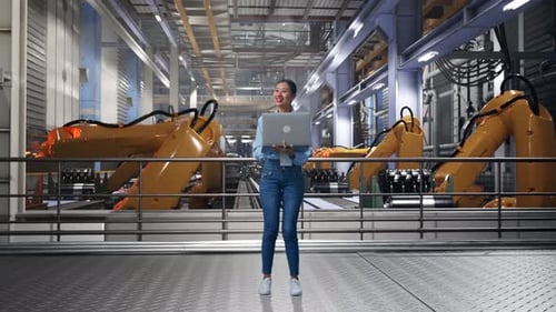 Woman Controls Factory Robots With Laptop