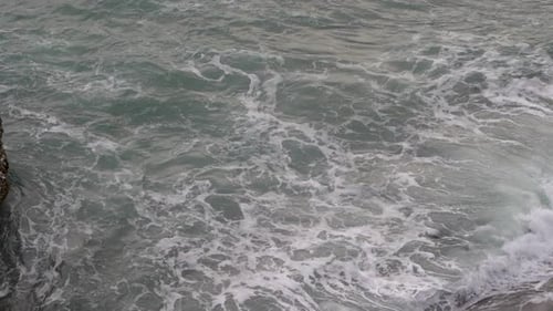 Swell at gray sea with white foam in slow motion