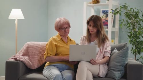 Senior Woman Learning to Use Laptop with Young Adult