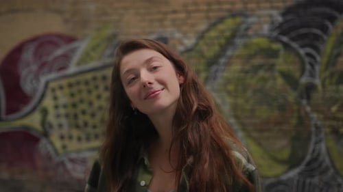Stylish Woman Posing in Front of Graffiti Wall