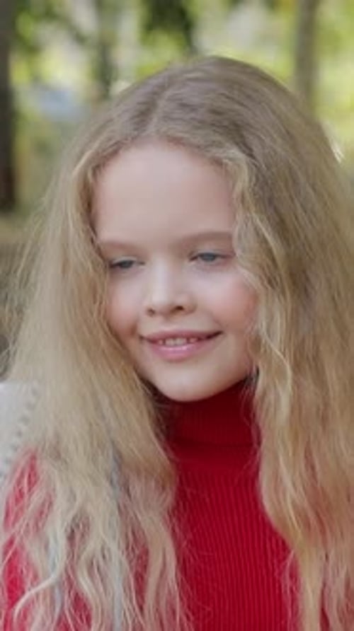 Une jeune fille sourit brillamment dans la beauté de la nature, mettant en valeur ses beaux cheveux bouclés et