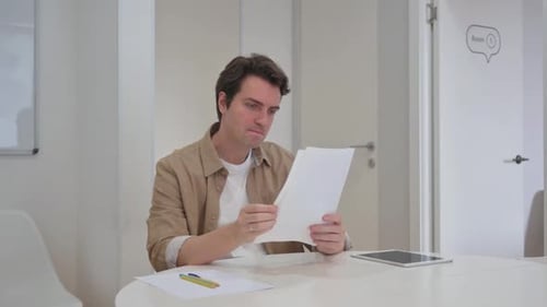 Man Reads Good News on Paper in Office