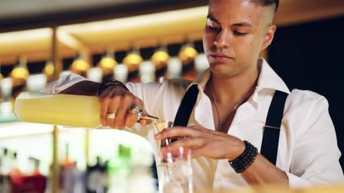 Barman professionnel versant de l'alcool dans un Jigger pour un cocktail