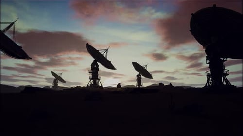 Satellite Dishes On Field Against Cloudy Sky During Sunset