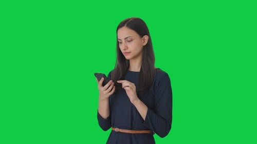 Indian girl scrolling through phone Green screen