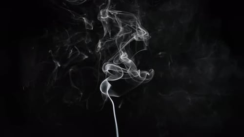 Wispy smoke drifting across a black background