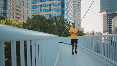 Man Runs on City Bridge on a Sunny Day