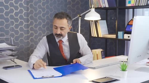Man Reviews Documents in Modern Office Setting
