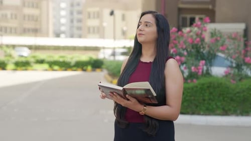 Young Woman Reading Book Outside on Sunny Day