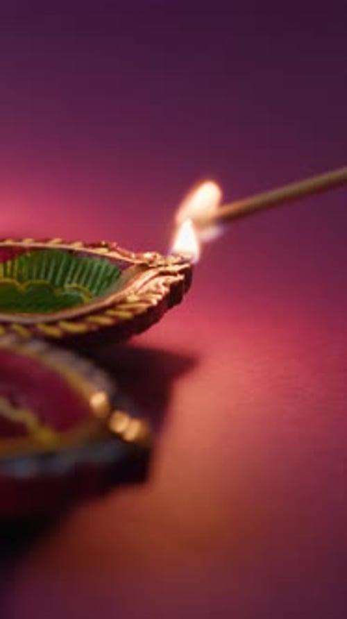 Hand Igniting Festive Diwali Diyas