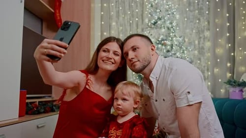 Happy Family Taking Christmas Selfie in Decorated Home