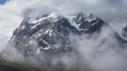 Pics rocheux escarpés avec neige et brouillard