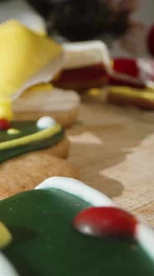 Vertical video. A Close-Up of a Christmas Tree Cookie Being Decorated with Yellow Icing,