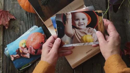Fotos de Halloween para álbum de fotos familiar, manos navegando, fotos impresas