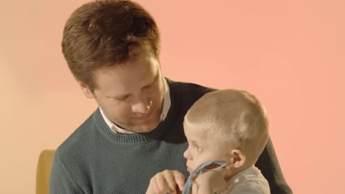 Father Holding Young Child with Toy