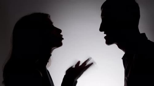 Ein Mann und eine Frau streiten sich aggressiv, Nahaufnahme ihrer Silhouetten. Konfliktkonzept.
Streit